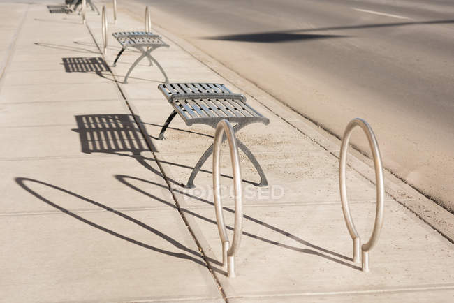 Asientos vacíos en la acera en un día soleado - foto de stock