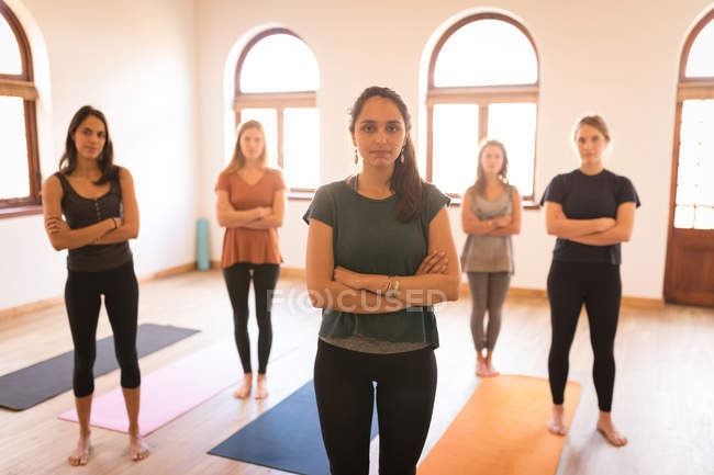 Group of women standing with arms crossed in fitness club — Stock Photo