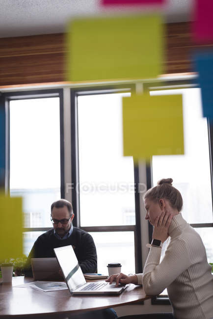 Business colleagues working on laptop and digital tablet in office — Stock Photo