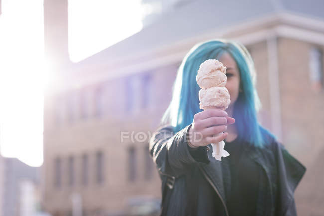 Mujer con estilo sosteniendo un helado en la calle de la ciudad - foto de stock