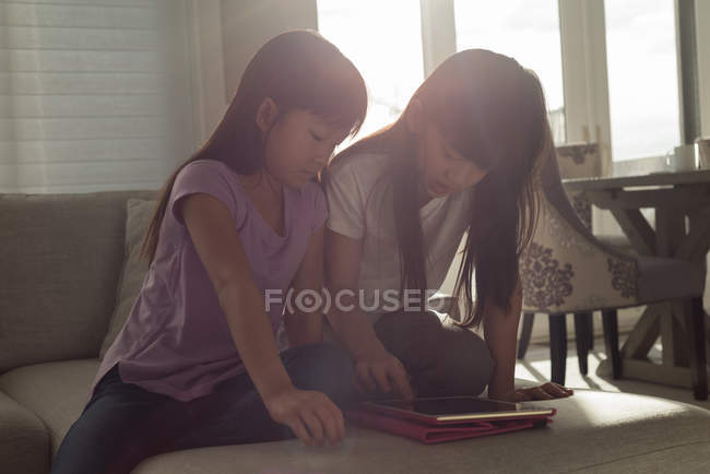 Geschwister nutzen digitales Tablet im heimischen Wohnzimmer — Stockfoto