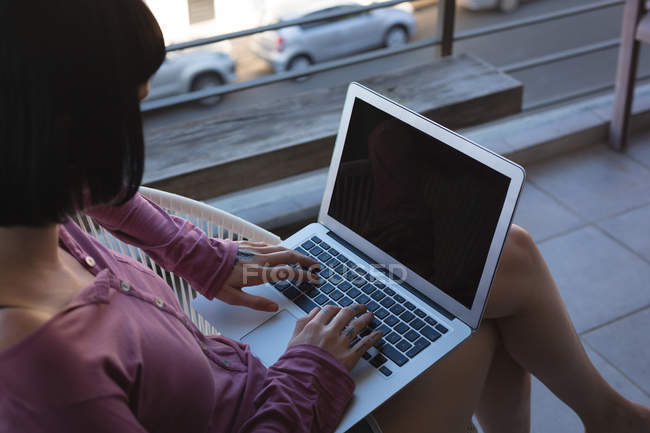 Женщина с ноутбуком на балконе дома — стоковое фото