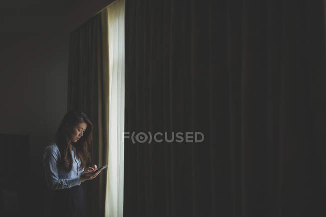 Бізнес-леді, використовуючи мобільний телефон в готельному номері — стокове фото