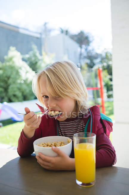 Garçon petit déjeuner dans le porche à la maison — Photo de stock