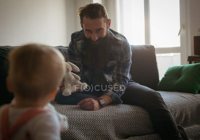 Pai brincando com seu bebê em casa — Fotografia de Stock