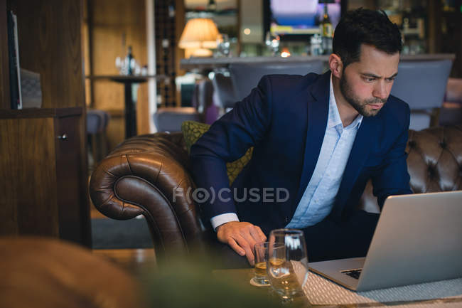 Businessman using laptop in hotel — Stock Photo
