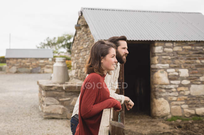 Thoughtful couple standing leaning on railing — Stock Photo