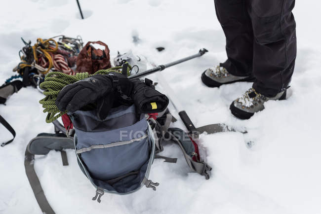 Низька частина ходунки, що стоїть з рюкзаком та обладнанням на сніговій області — стокове фото