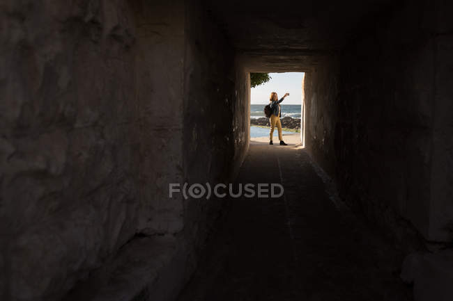Femme prenant selfie dans la voûte de bâtiment à la plage au soleil — Photo de stock
