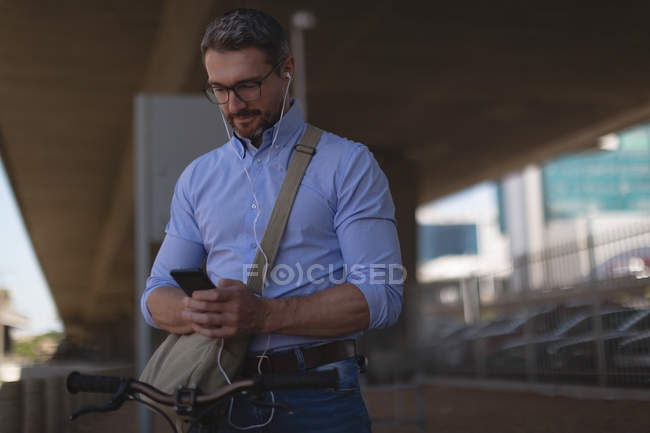 Улыбающийся человек с мобильного телефона под мостом — стоковое фото
