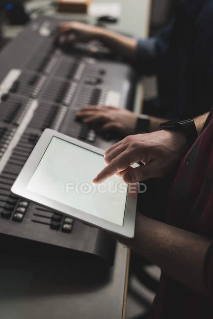 Hands of two sound mixers using digital tablet in studio. — Stock Photo