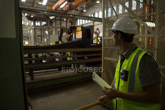 Marine-Ingenieur steht mit Klemmbrett in Werkstatt — Stockfoto
