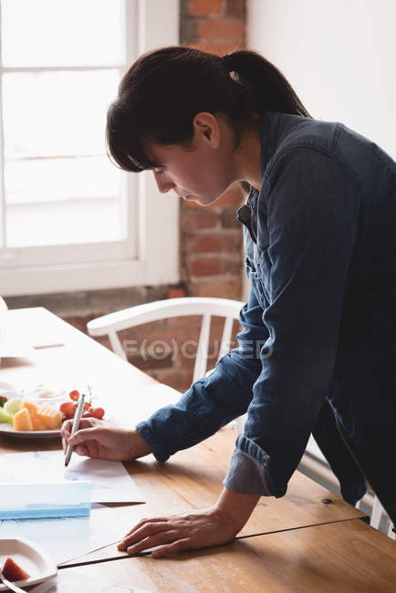 Female executive checking a documents in the creative office — Stock Photo