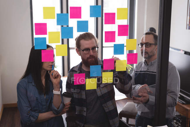 Business colleagues writing on sticky notes in office — Stock Photo