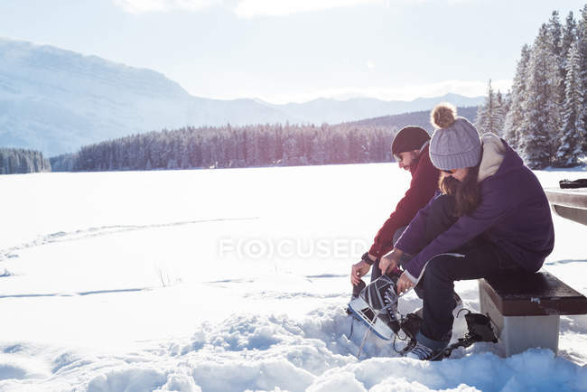 Couple portant des patins dans un paysage enneigé en montagne . — Photo de stock