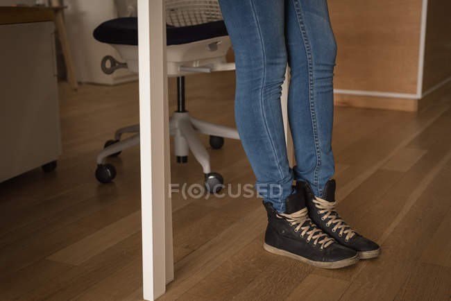 Низька секція жіночої виконавчої влади, що стоїть на дерев'яній підлозі в творчому офісі — стокове фото