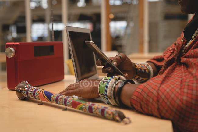 Mid section of maasai man in traditional clothing using mobile phone — Stock Photo