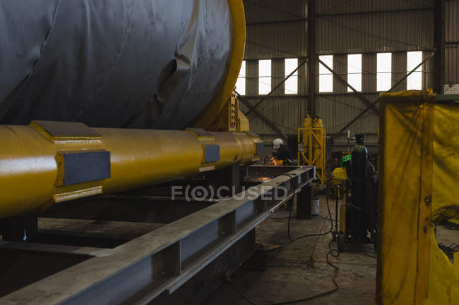 Welder repairing vessel part in workshop — Stock Photo