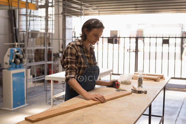 Junge Kunsthandwerkerin arbeitet in Werkstatt. — Stockfoto