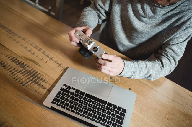 Mid section of man using vintage camera at home — Stock Photo