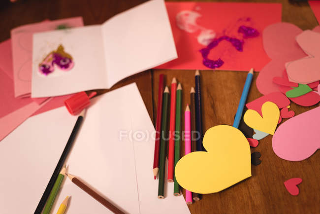 Gros plan de l'artisanat en forme de coeur et crayon de couleur sur le sol en bois — Photo de stock