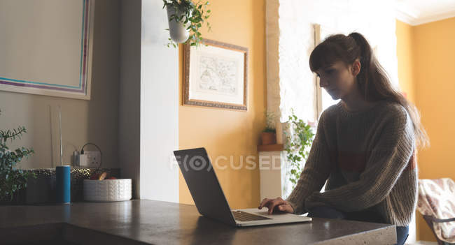 Donna che utilizza il computer portatile a casa — Foto stock