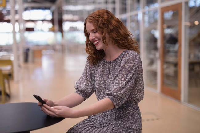 Femme cadre utilisant le téléphone portable dans le bureau — Photo de stock