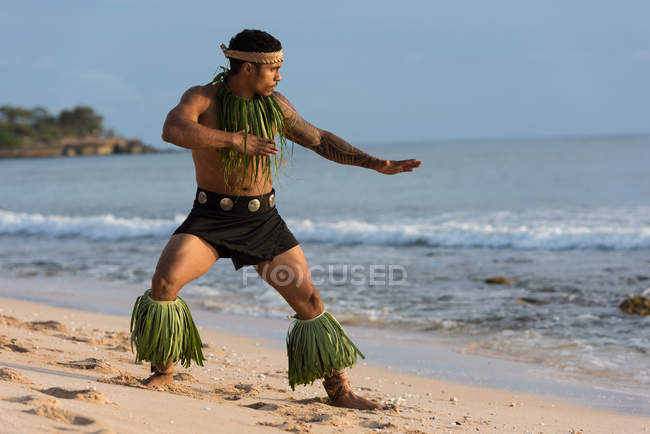 Ballerino di sesso maschile esibendosi in spiaggia in luce soffusa — Foto stock