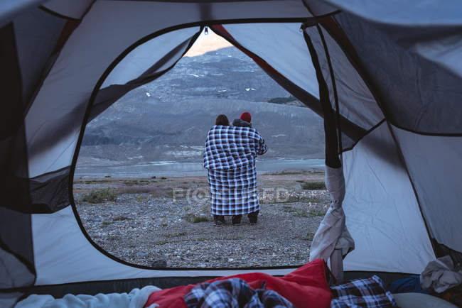 Vista posteriore di coppia in piedi con avvolto in coperta — Foto stock