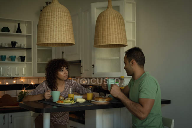 Pareja desayunando juntos en casa - foto de stock