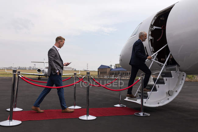 Посадка бизнесменов на частный самолет в терминале — стоковое фото