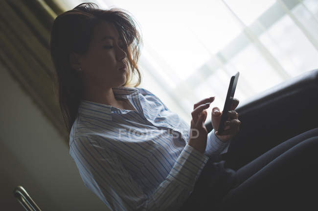 Femme d'affaires utilisant le téléphone portable dans la chambre d'hôtel — Photo de stock