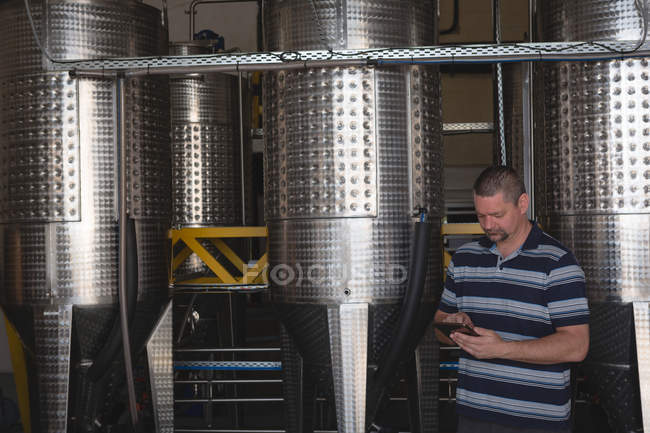 Чоловічий працівник використовує цифровий планшет на заводі джин — стокове фото