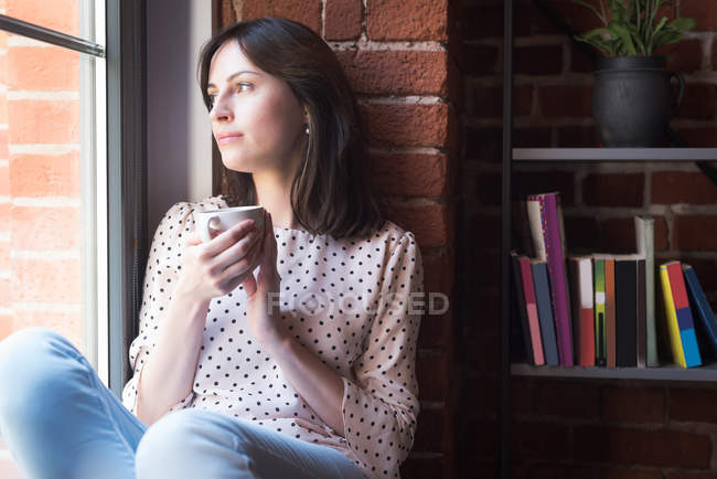 Young female executive having coffee in office — Stock Photo
