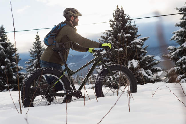 Homem caminhando com bicicleta na paisagem nevada durante o inverno . — Fotografia de Stock
