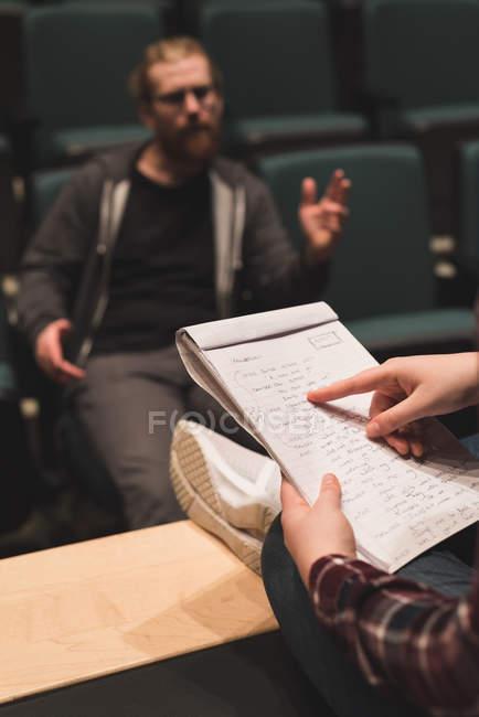 Female actress discussing script with male actor on stage at theatre. — Stock Photo