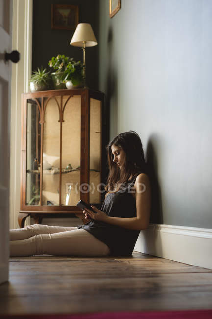 Жінка використовує мобільний телефон вдома — стокове фото