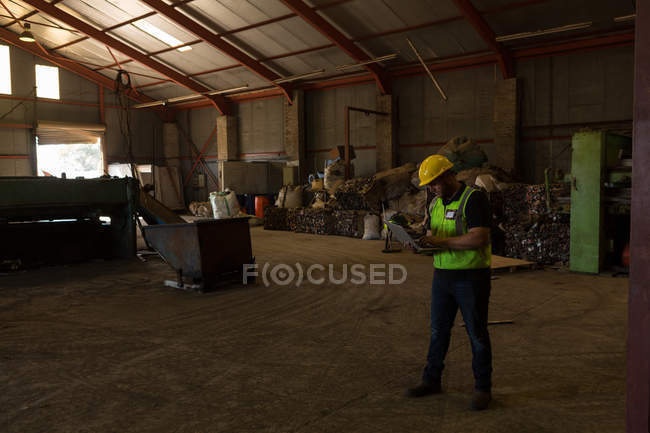 Concentrated worker using laptop in the scrapyard — Stock Photo