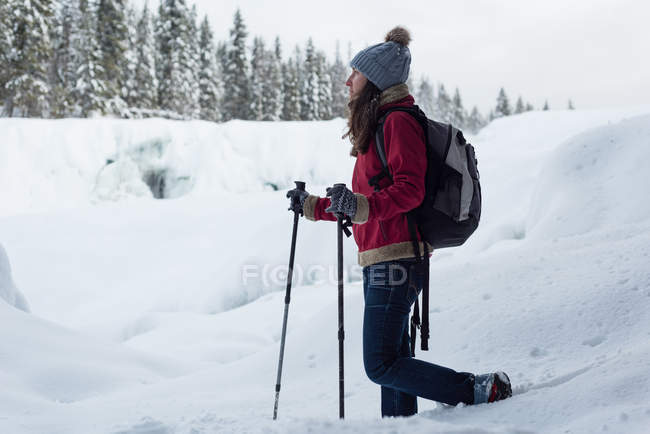 Esquiador feminino caminhando na paisagem nevada durante o inverno — Fotografia de Stock