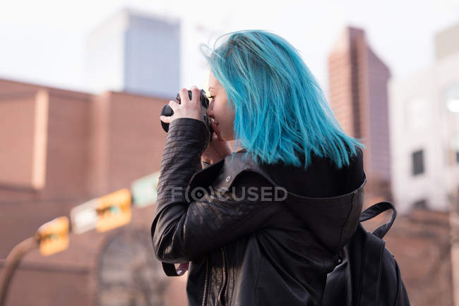 Стильна жінка фотографує з камерою на міській вулиці — стокове фото