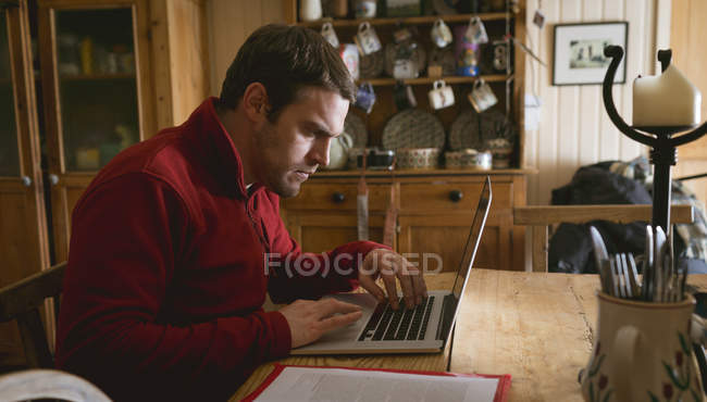 Уважний чоловік використовує ноутбук вдома — стокове фото