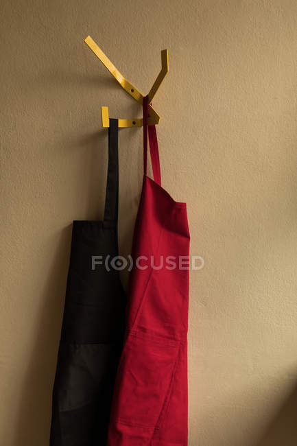 Aprons hanging on wall in coffee shop — Stock Photo