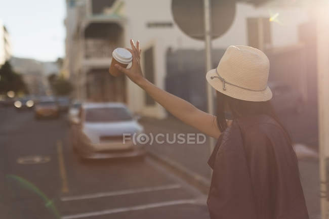 Женщина жестикулирует на городской улице в солнечный день — стоковое фото