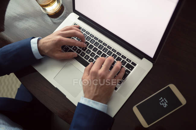 Seção média de homem de negócios usando laptop no hotel — Fotografia de Stock