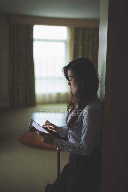 Femme d'affaires utilisant une tablette numérique dans la chambre d'hôtel — Photo de stock