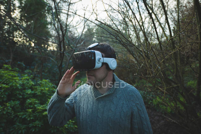 Homem usando headset realidade virtual na floresta no campo — Fotografia de Stock