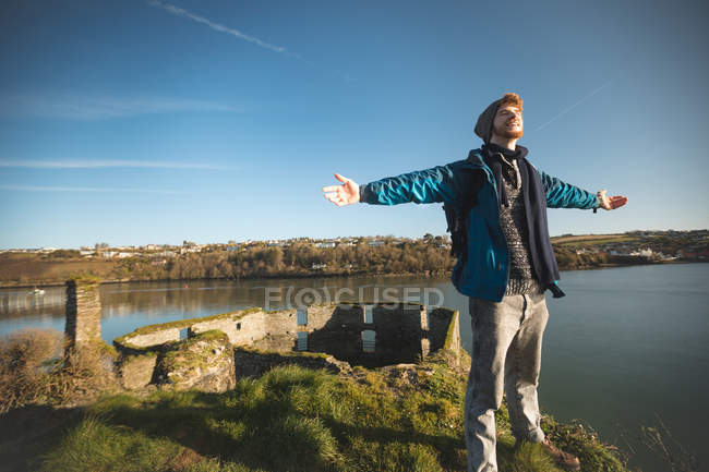 Jeune randonneur homme debout les bras tendus à la campagne — Photo de stock