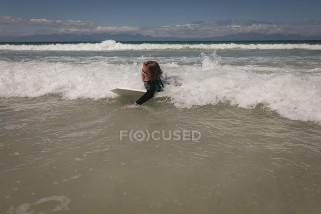 Mädchen surft an einem sonnigen Tag im Meer — Stockfoto