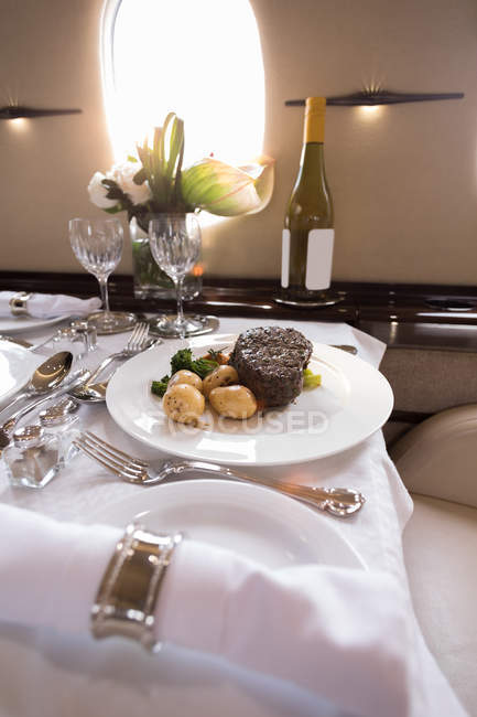 Comida e bebida servidas em uma mesa em jato privado — Fotografia de Stock