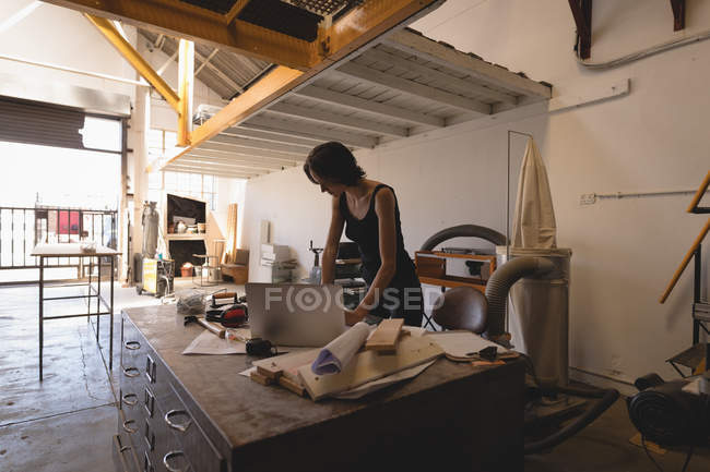 Jovem artesã do sexo feminino trabalhando no interior oficina . — Fotografia de Stock